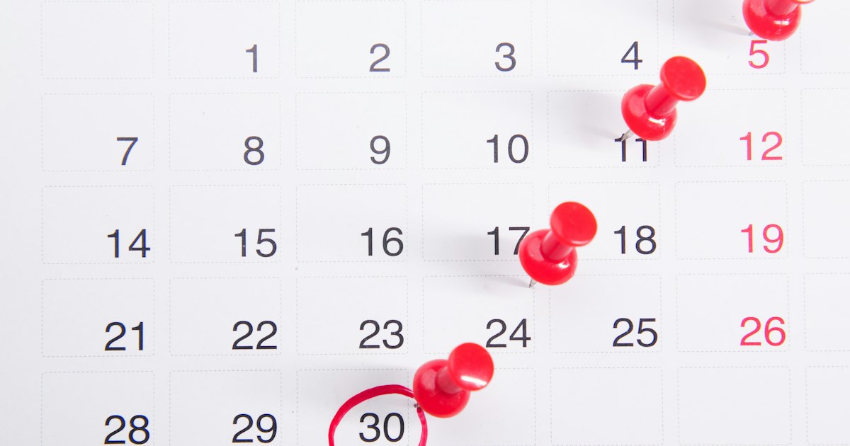Calendario mensual con varias fechas marcadas con chinchetas rojas