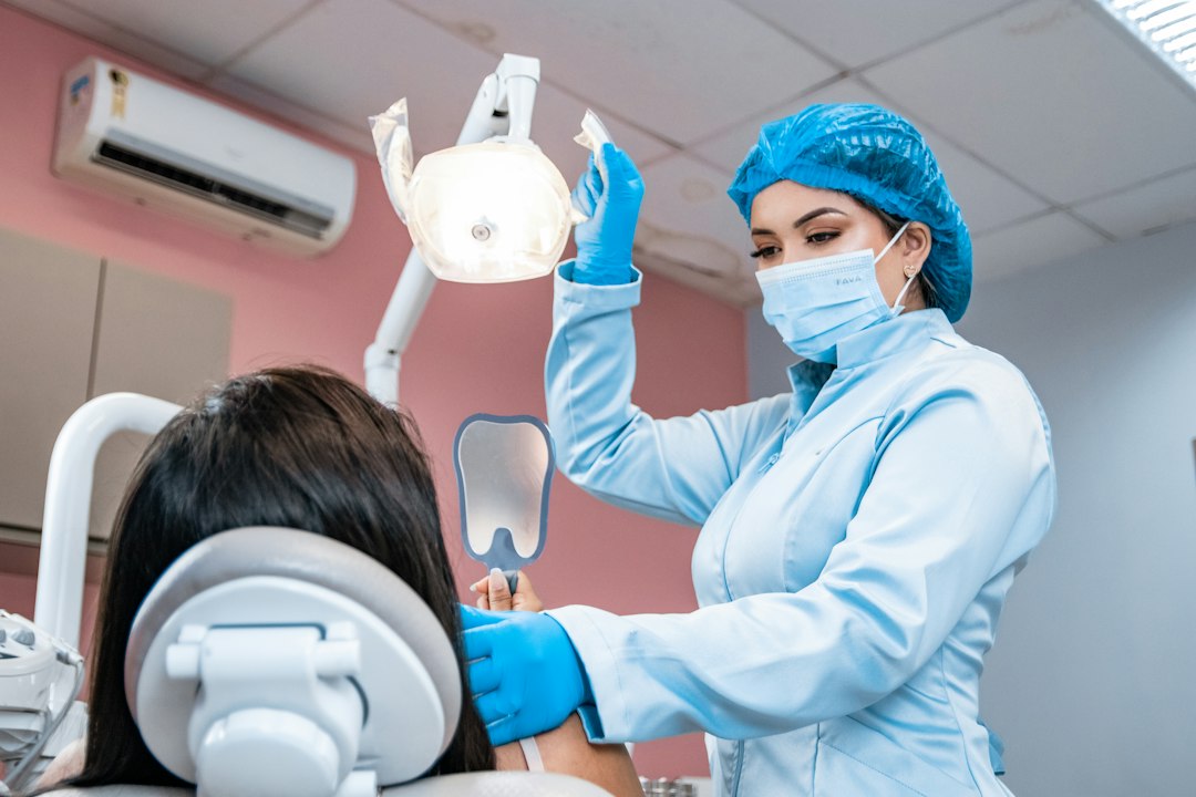 Dentista revisa los dientes de una paciente recostada en el sillón dental