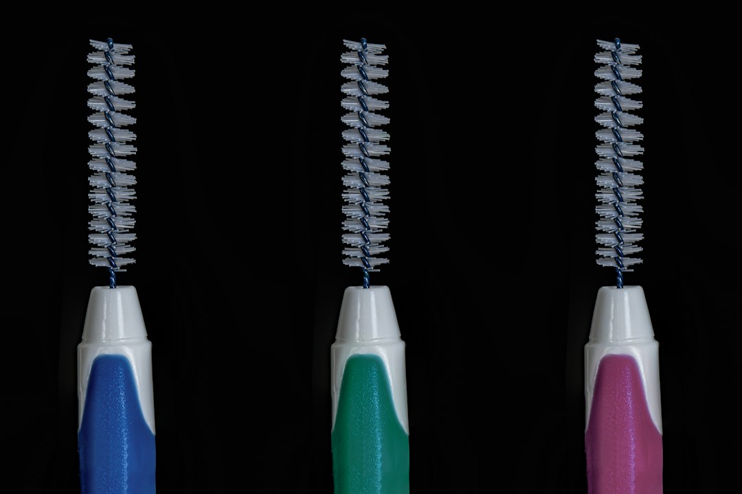 Three colorful interdental brushes on a black background