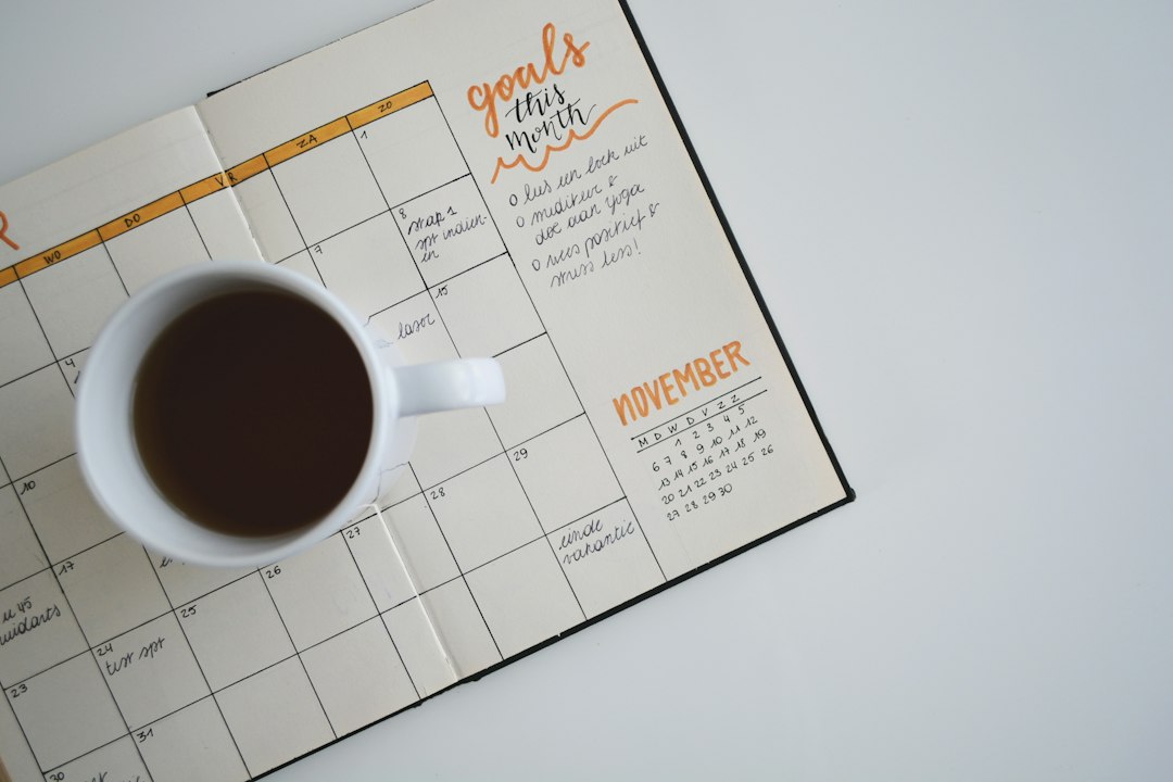 Coffee cup on an open monthly planner with notes