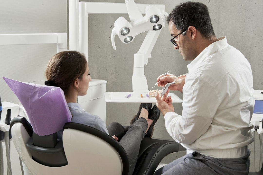 Seated dentist talking with a patient in the dental office before care